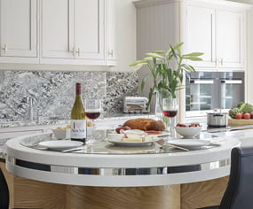 Luxury bespoke kitchen with curved island, marble splashback and cream shaker cabinetry, designed and built by Nureno in Oxfordshire